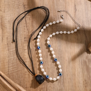 Detail der Perlenkette mit blauen Evil-Eye-Perlen und Naturstein-Anhänger im Boho-Stil