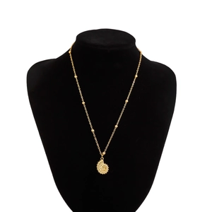 Detailed view of a gold nautilus shell pendant on a black velvet display stand
