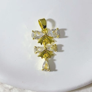 Gouden dubbele strik hanger met fonkelende peer-vormige zirkonia kristallen aan een ketting