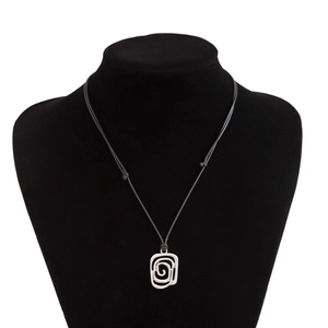 Detail of silver conch pendant with spiral cutout on black cord necklace for women