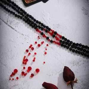 Detailed view of layered Gothic beaded necklace with red crystal blood drip tassels
