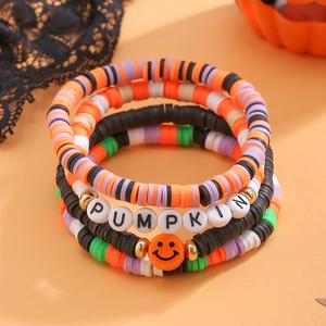 Dettaglio del set di cinque braccialetti elastici con perline e scritta PUMPKIN colorata