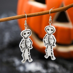 Close-up of white acrylic skeleton earrings hanging on a wood branch for Halloween