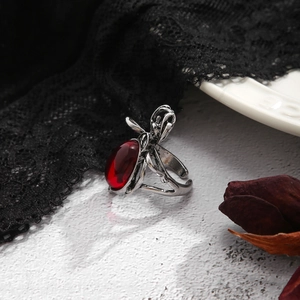 Makroaufnahme eines gotischen Silberrings mit ovalem rotem Edelstein und Spinnen-Design