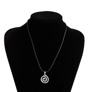 Macro shot of silver spiral pendant with black woven cord on a jewelry display stand