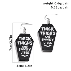 Detail of glittery coffin acrylic earrings with size and weight measurement specs