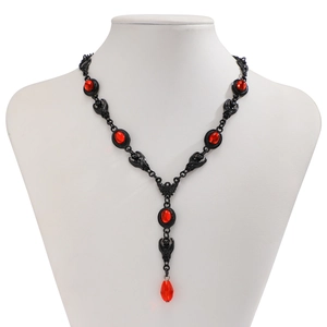 Close-up of Gothic red gemstone necklace on a bust showing intricate hollow patterns