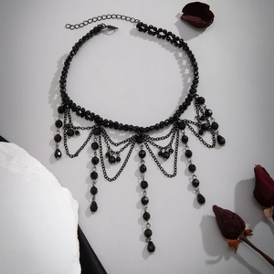 Gothic choker close-up with black beads, dark metal chains and water drop tassels