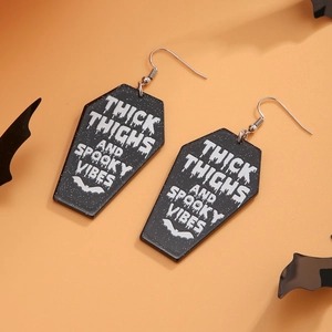 Detail of acrylic coffin earrings with Gothic text and bat icon for Halloween