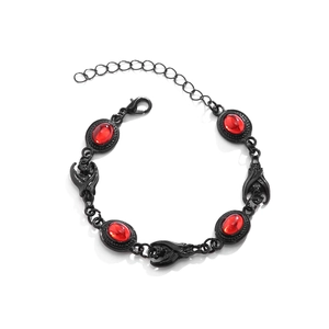 Macro detail of Gothic bat link bracelet featuring red oval gems and black plating