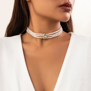 Gros plan d'un choker en perles à trois rangs avec pendentif en cristal sur un mannequin