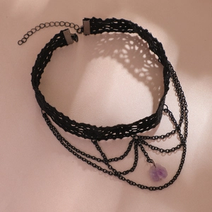 Ras de cou en dentelle noire avec pendentif cristal violet et chaînes sur fond rose