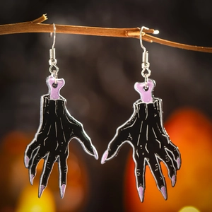 Close-up of black acrylic zombie claw earrings for Halloween with purple bone accents