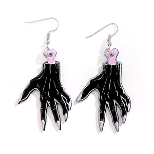 Macro shot of gothic zombie hand acrylic earrings with pink bone details and silver hooks