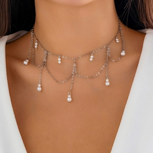 Close-up of silver layered choker necklace with white imitation pearls and flowing tassels