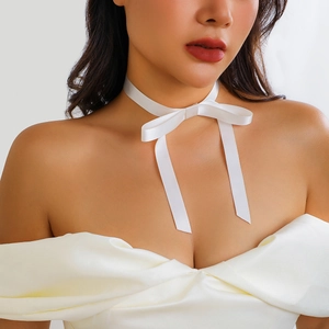 Detail eines weißen Satin-Chokers mit eleganter Schleife und fließenden Bändern am Hals