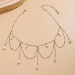 Detailed view of silver tassel body chain with white faux pearls and lobster clasp
