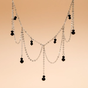 Detailed view of gothic silver-tone chain choker with elegant black bead tassel tassels