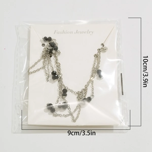 Detail of beaded multilayer necklace with black faceted beads in package 10x9cm