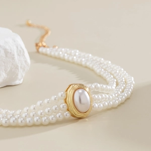 Vue détaillée du choker à trois rangs de perles avec finitions dorées et turquoise