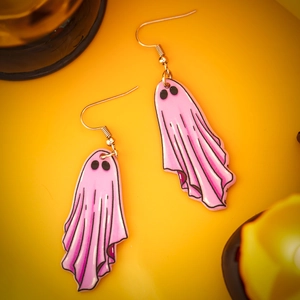 Detailed view of pink acrylic ghost earrings with black eyes and metal hooks for Halloween