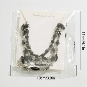 Detailed view of Gothic black beaded choker with crystal droplets in display packaging