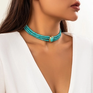 Collier ras-du-cou turquoise à trois rangs avec pendentif ovale doré sur un mannequin
