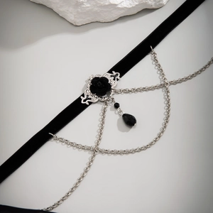Detail eines Gothic-Chokers mit schwarzem Samt, Silberkette und Rosenanhänger