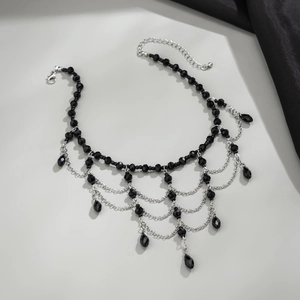 Detailed close-up of gothic beaded choker with black faceted beads and tassel fringe drops