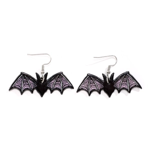Detail of bat-shaped acrylic earrings with purple striped wings for Halloween style