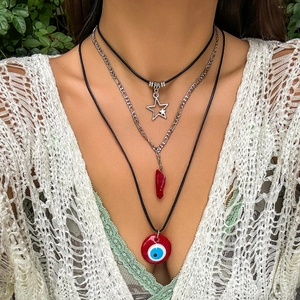 Nahaufnahme von Boho-Halsketten mit Stern- und Augenanhängern an einem Model