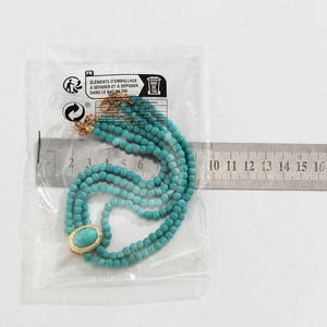 Détail du collier de perles turquoise à plusieurs rangs avec fermoir doré serti de gemmes