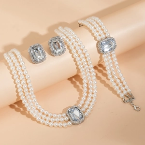 Vue détaillée d'une parure de bijoux en perles triple rang avec cristaux émeraude