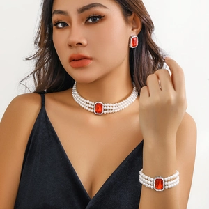 Détail d'un ensemble de bijoux en perles à trois rangs avec pierres rouges rectangulaires