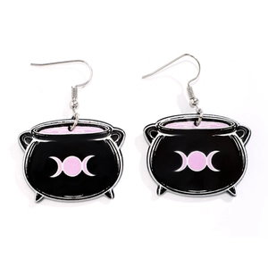 Detail of black acrylic cauldron earrings with pink triple moon symbol for Halloween