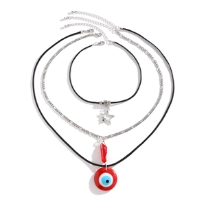 Details eines dreiteiligen Halsketten-Sets mit Stern-Anhänger und rotem Evil-Eye-Amulett