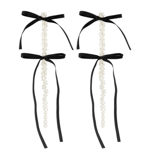 Elegant long drop pearl earrings featuring vintage black velvet bows on a clean background