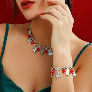 Kerstset met ketting en armband met hangers van boom en rendier op een rode achtergrond