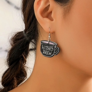 Close-up of Witches Brew acrylic cup earring worn on ear for Halloween style