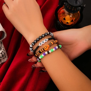 Dettaglio di quattro braccialetti di perline per Halloween con ciondoli Spooky e Boo al polso