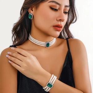 Gros plan d'une parure de perles multicouches avec pierres vertes et diamants brillants