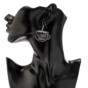 Detail of Witch's Brew acrylic earrings featuring black cauldron design and text
