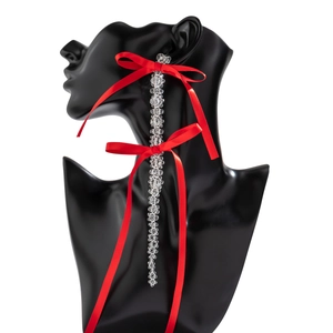 Detail of long red satin bow earrings with sparkling clear beaded tassels