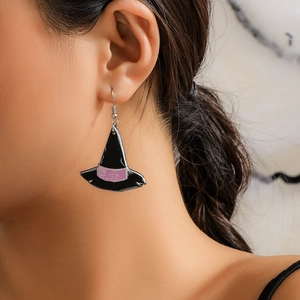 Close-up of a black acrylic witch hat earring with pink ribbon and purple star detail