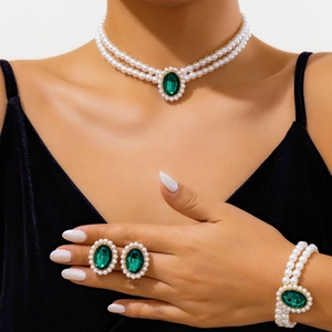 Détail d'un ensemble de bijoux en perles avec pierre précieuse verte et petites perles