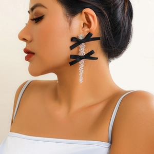 Detail of long black ribbon bow earrings with dangling transparent beaded chains