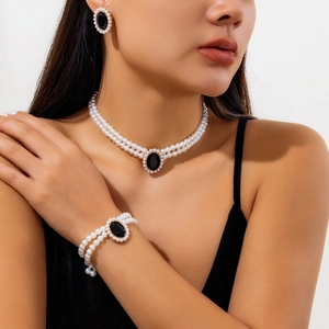 Détail d'une élégante parure de bijoux en perles avec pierre précieuse noire sur un mannequin