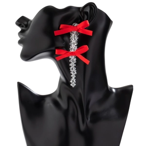 Detail of long drop earrings with red silk bows and clear faceted crystal beads on model