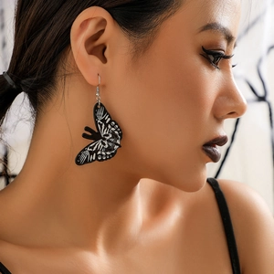 Detailed close-up of gothic acrylic butterfly earrings with skeleton bone patterns
