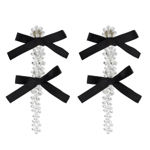 Detail of long hair clips featuring clear faceted beads and black satin ribbon bows